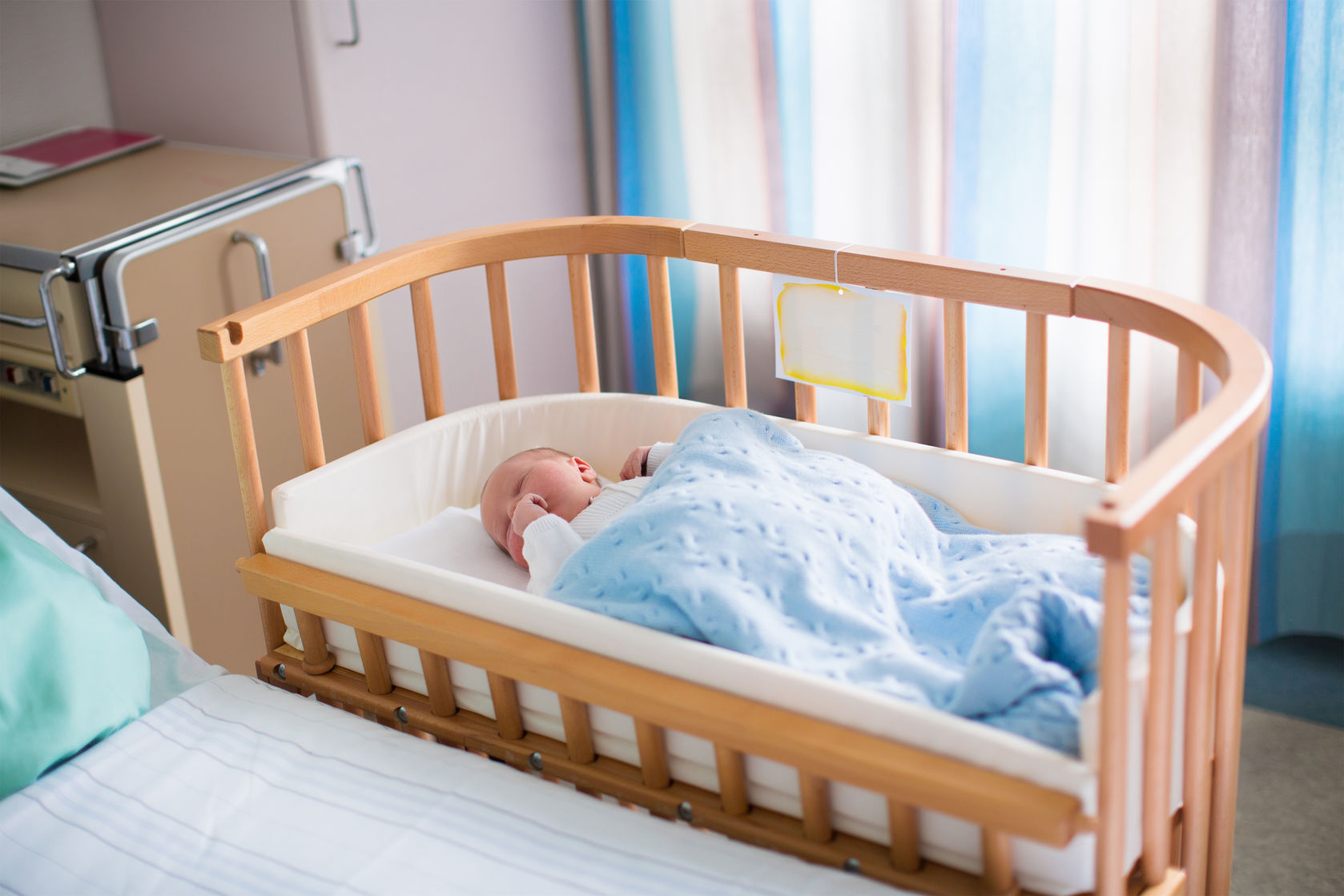 bebé durmiendo en colecho seguro con cuna junto a la cama de los padres